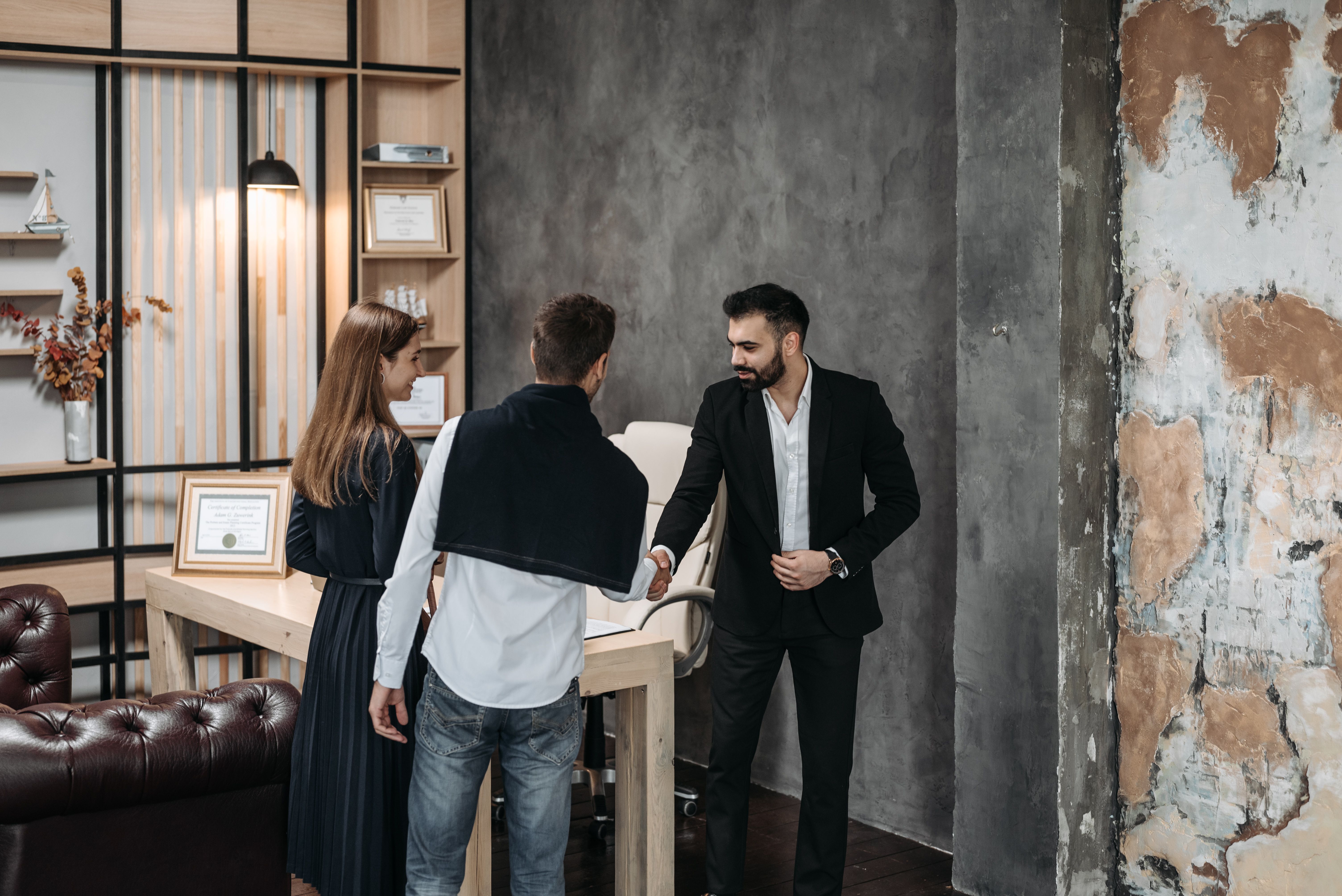 Dos personas conversan alrededor de una mesa en un espacio luminoso.